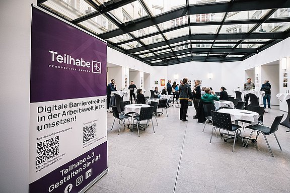 Fachtagung Teilhabe 4.0 Eingangsbereich der Fachtagung im Februar 2024 mit einem Aufsteller des Projekts im Vordergrund.